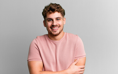 young adult caucasian man laughing shyly and cheerfully, with a friendly and positive but insecure...