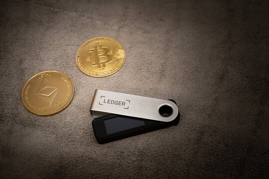 Ledger Nano s crypto hardware wallet with bitcoin and Ethereum coins on dark leather