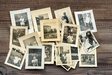 Fototapeta na wymiar Vintage family photos wooden table background. Old pictures used paper