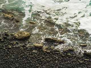Beautiful seascape. White foamy sea waves crash against the rocky shore. Beautiful nature, deserted place. Environmental protection, climate change, ecology.