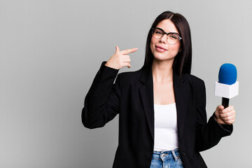 smiling confidently pointing to own broad smile. journalist or presenter with a micro