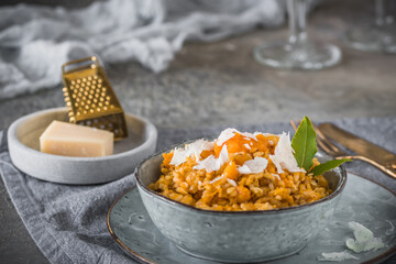 Homemade pumpkin risotto with parmesan cheese on a gray concrete background