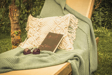Garden lounger with book and blanket