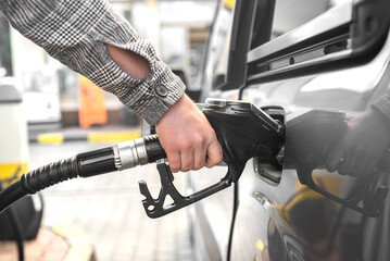 A man is filling up his car. Refueling the car. Rising gasoline prices.