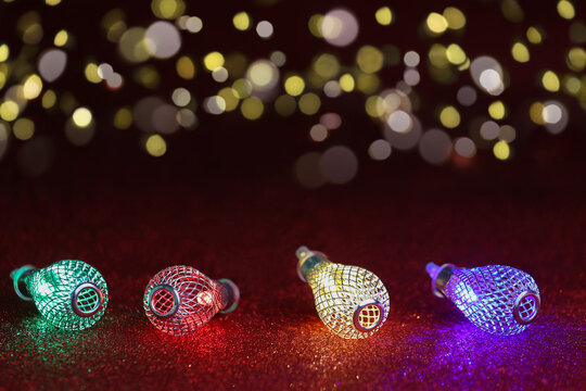 Garland with colorful lights, red glitter base, defocused lights in the back