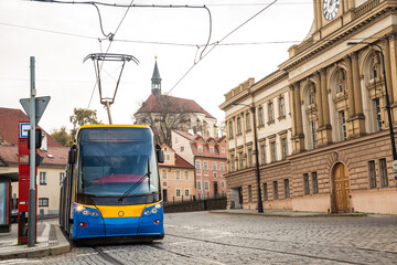 Fototapeta na wymiar Modern Tram in old stree of Prague in a summer day, Czech Republic. The Prague tram network is the third largest in the world. Passenger Eco-friendly electric transport connection in the Europe City