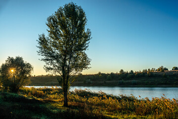 Lake in autumn , water reflections .Autumn landscape in the morning , forest and lake .Autumn colors ,sun over the lake, yellow colors , blue sky without clouds . Morning beauti . Beautiful nature.
