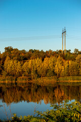 Lake in autumn , water reflections .Autumn landscape in the morning , forest and lake .Autumn colors ,sun over the lake, yellow colors , blue sky without clouds . Morning beauti . Beautiful nature.