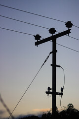 Electric pole silhouette with morning sky background.