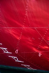 Side of a ship showing the construction of the hull in red with depth gauge and rivets