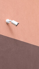 Surveillance camera on a two-tone wall. Security home equipment house safe concept
