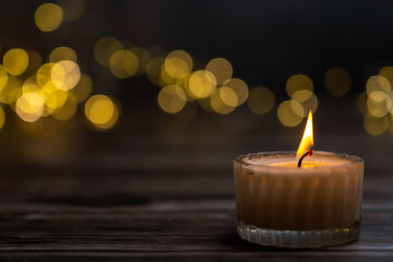 burning candle in the dark. Christmas lights in the background, Christmas mood