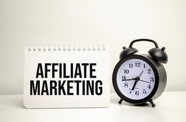 AFFILIATE MARKETING words with calculator and clock with notebook