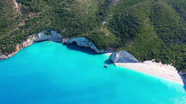 Aerial drone video of tropical paradise island covered in pine trees with turquoise crystal clear beach in paradise island destination resembling a blue lagoon