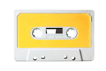 Isolated old vintage cassette tape from the 1980s (obsolete music technology). White-grey plastic body and warm yellow label.
