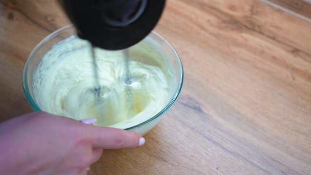 Beat mixer cream, for cake on decor. Whipping butter cream with a mixer.
