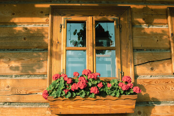 Fototapeta na wymiar Nicely decorated window of a log cabin house.