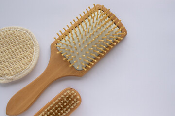 Beauty accessories wooden comb, nail brush, facial sponge on white background. Modern paddle hair...