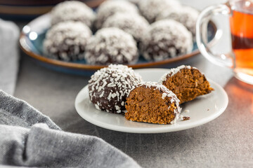 Coconut chocolate balls on plate on kitchen table.
