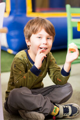 A kid eats a cupcake. Handsome boy has a Happy Birthday party. Portrait of a Preschool smiling Boy.