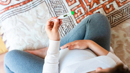 Pregnant headache fever sick. Pregnancy woman holding thermometer, check fever flu temperature....