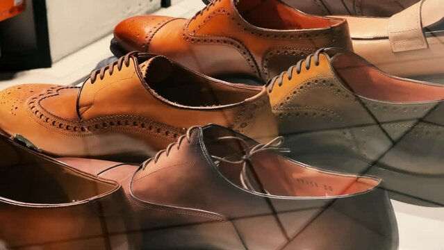 Brown men's oxfords stand in the window of a shoe store