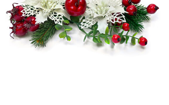 Christmas decoration. White openwork flowers poinsettia, branch christmas tree, red berries, apples on white background with space for text