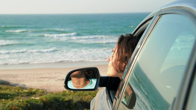 Brunette woman with short hair looking out of the window while sitting at the driver place