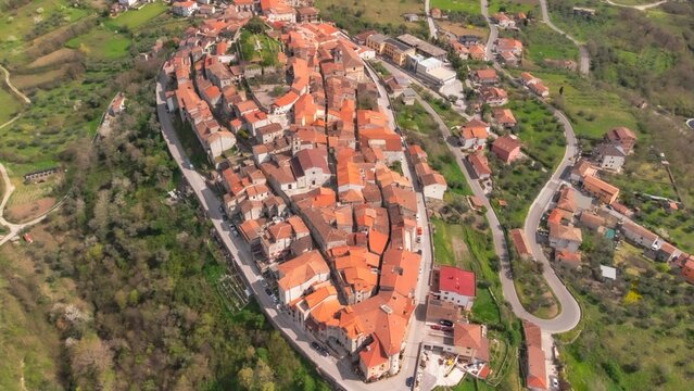 Aerial Shot Of A Neighborhood With Close-placed Buildings Surrounded By A Meadow