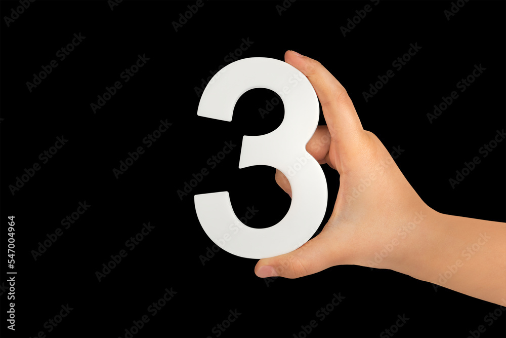Poster number three in hand isolated on black background. number three in a child's hand on a black backgro