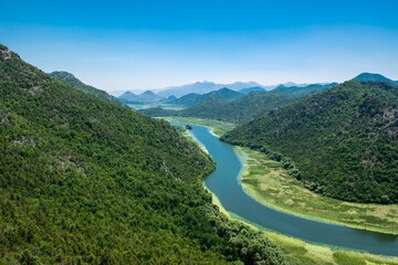 Pavlova Strana View Point. Beautiful summer landscape of green mountains, blue sky and Crnojevica river that flows into Skadar Lake. Montenegro.