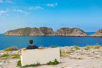 Islas Malgrats (Mallorca). Hombre contemplando el mar, sentado en un banco de piedra frente a las...