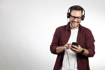 Young casual dressed man enjoying in his favourite music. Studio portrait photo, taken on white background