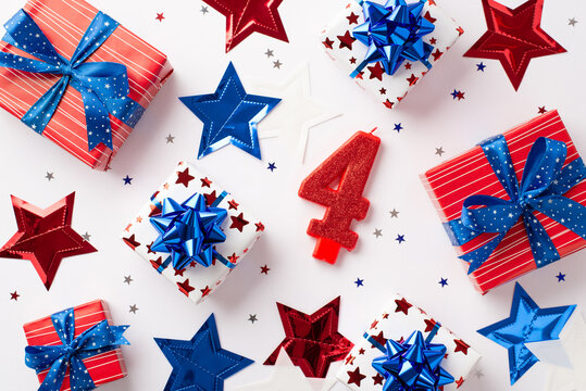 Forth of July celebration concept. Top view photo of number 4 candle gift boxes in national flag colors star garland and confetti on isolated white background