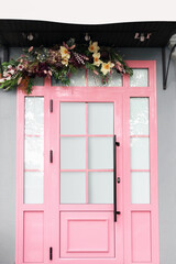 Building with stylish pink door and floral decor