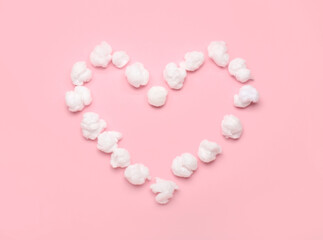 Heart made of soft cotton wool on pink background