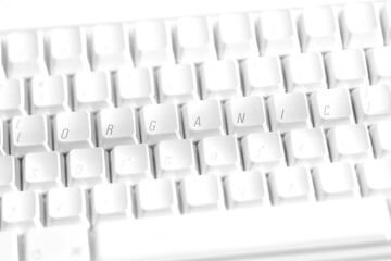 A white keyboard with the letters rearranged to spell the word organic