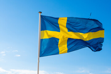 Swedish flag waving against blue sky