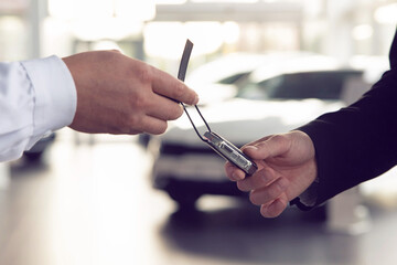 Car salesman gives the keys to the customers who signed the purchase contract