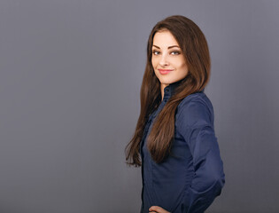 Obraz premium Beautiful confident thinking smiling business woman in blue formal shirt on grey background with empty copy space for text. Closeup