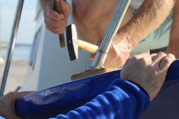 Two men fixing a fishing boat with their hands