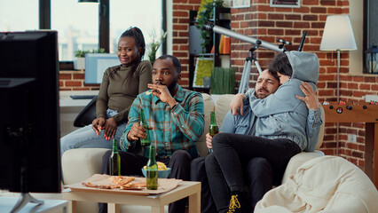 Multiethnic group of people getting scared watching horror film, gathering at home to watch thriller. Friends being terrified of scary movie, having shocked frightened reaction. Tripod shot.