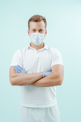 Doctor standing with hands crossed on light blue background. Healthy concept