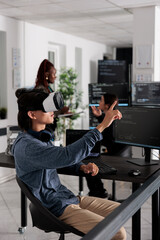 Software developer wearing virtual reality headset working to develop security program in it...