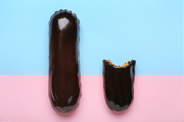 Whole and bitten chocolate eclairs on color background