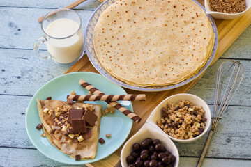 Crepes with chocolate on cutting board with ingredients