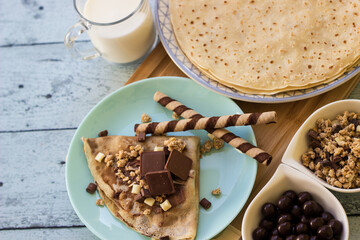 Crepes with chocolate on cutting board with ingredients