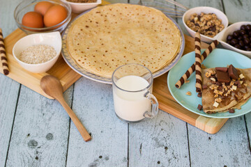 Crepes with chocolate on cutting board with ingredients