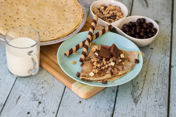 Crepes with chocolate on cutting board with ingredients