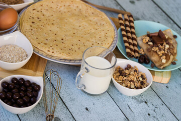 Crepes with chocolate on cutting board with ingredients